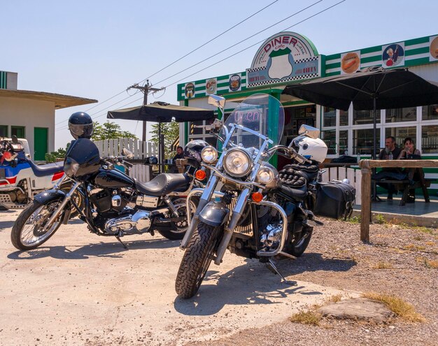 Les motos et les motocyclistes se tiennent à l'extérieur du bar des motards en Grèce