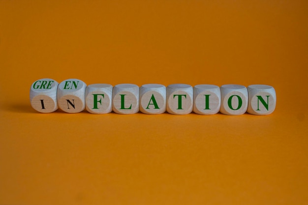 Photo mots conceptuels inflation ou greenflation sur des cubes de bois belle table orange fond orange