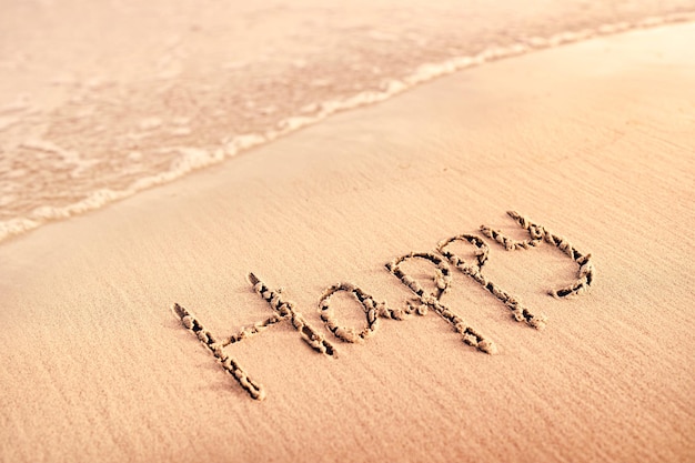 Mots heureux écrits dans le sable sur la plage.