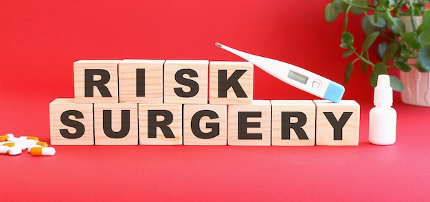 Les mots RISK SURGERY sont constitués de cubes en bois sur fond rouge. Notion médicale.