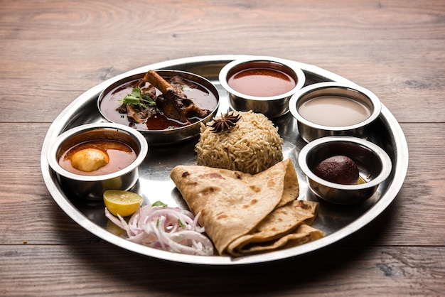 Motton Thali OU Gosht, le plateau d'agneau est un menu de déjeuner ou de dîner asiatique non végétarien composé de viande, d'œufs au curry avec chapati, riz, salade et Gulab Jamun sucré