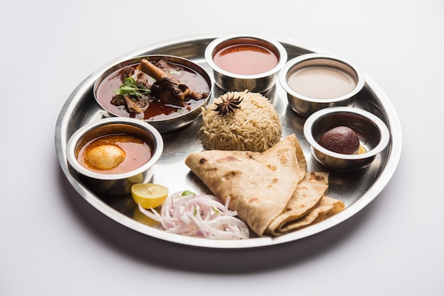 Motton Thali OU Gosht, le plateau d'agneau est un menu de déjeuner ou de dîner asiatique non végétarien composé de viande, d'œufs au curry avec chapati, riz, salade et Gulab Jamun sucré