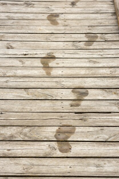 Mouiller les empreintes de pas humaines sur des planches de bois