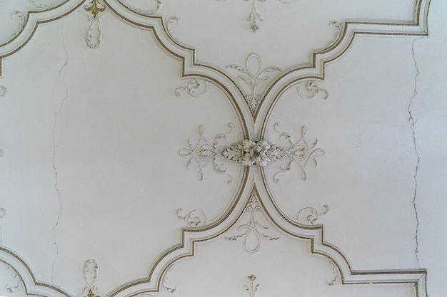Moulage en relief en stuc d'argile décorative vintage antique ronde avec ornements floraux sur plafond blanc dans un intérieur de style classique abstrait