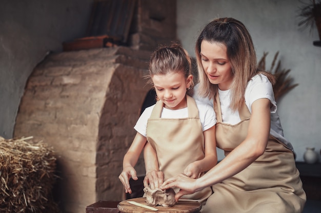 Moule pour mère et fille avec de l'argile, appréciant l'art de la poterie et le processus de production