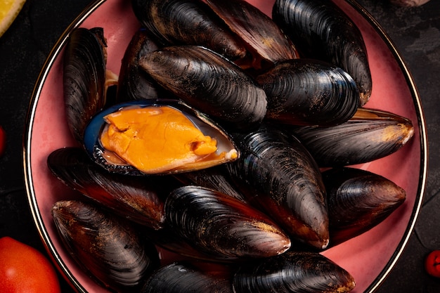 Moules crues noires sur une assiette close up