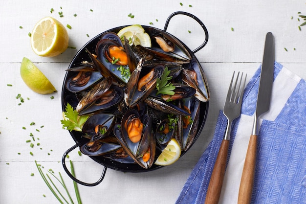 Des moules cuites à la vapeur vues d'en haut sur une table en bois