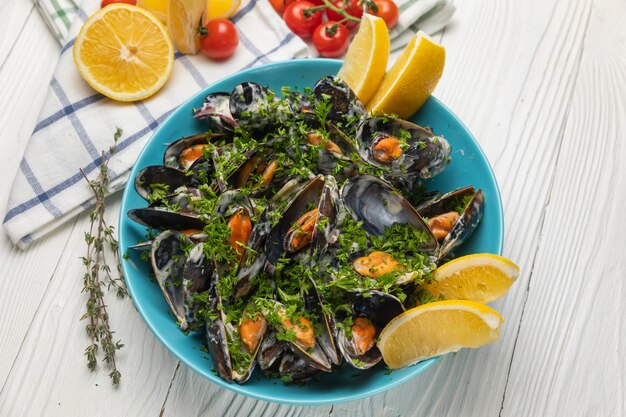 Moules dans une assiette au citron sur un tableau blanc