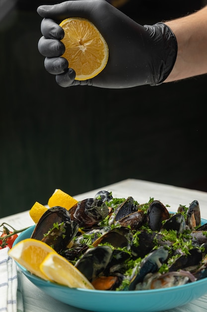 Moules dans une assiette au citron sur un tableau blanc