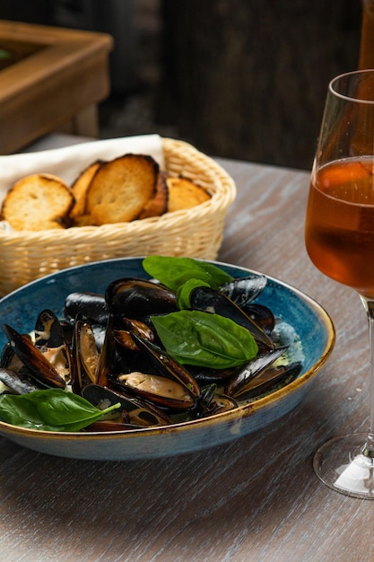 Moules dans une sauce crémeuse avec croûtons et un verre de vin