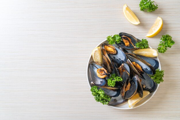 moules fraîches aux herbes dans un bol au citron