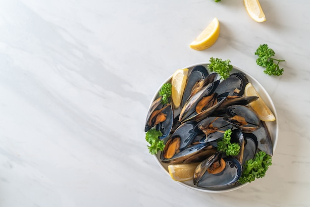 moules fraîches aux herbes dans un bol au citron