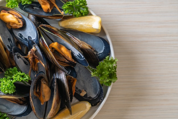 moules fraîches aux herbes dans un bol au citron