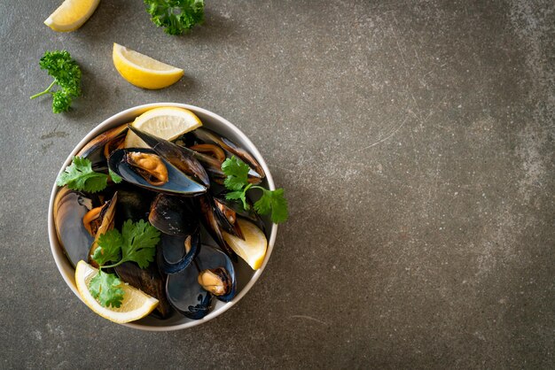 moules fraîches aux herbes dans un bol au citron