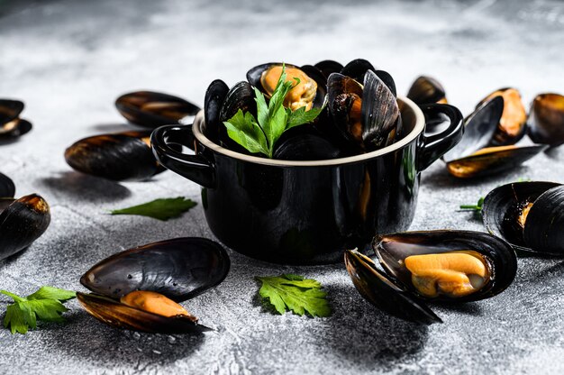 Moules fraîches en sauce au vin. Le concept de cuisson des fruits de mer. Fond gris. Vue de dessus