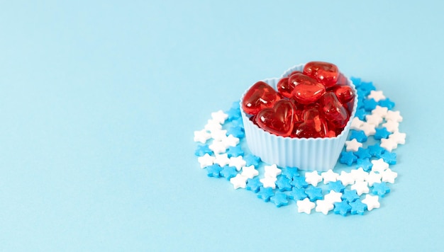 Moules à muffins avec coeurs rouges et pépites de bonbons sur bleu