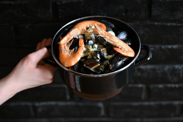 Photo les moules en sauce et crevettes sur fond noir