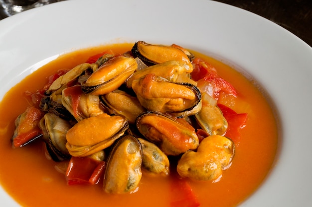 Moules à la sauce tomate sur une assiette blanche