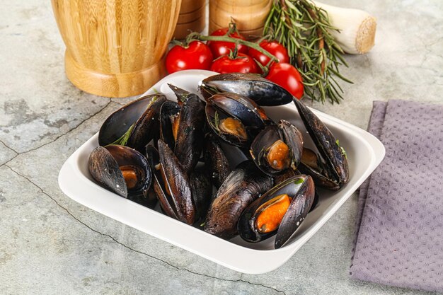 Des moules savoureuses dans le bol avec des herbes