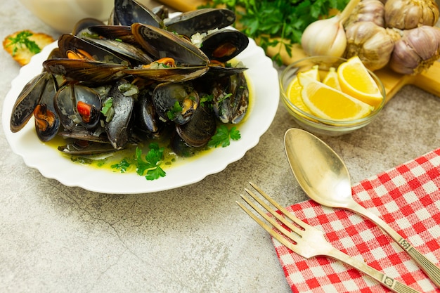 Moules et toasts de pain sur table en pierre avec cuillère et fourchette