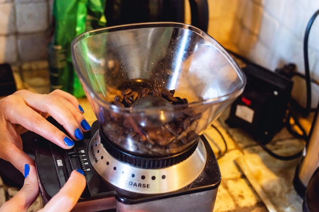 Moulin à café électrique fait maison sur le comptoir avec des grains de café entiers