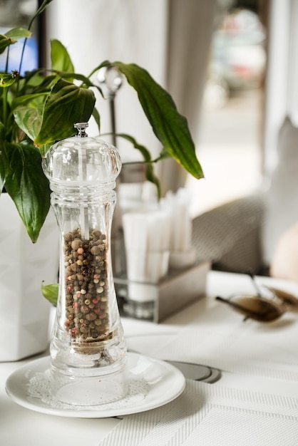 Moulin à poivre en verre sur la table servie au café