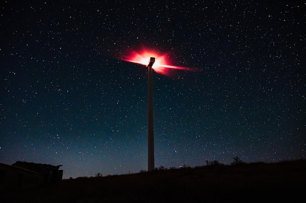 Moulin à vent avec des étoiles en arrière-plan la nuit