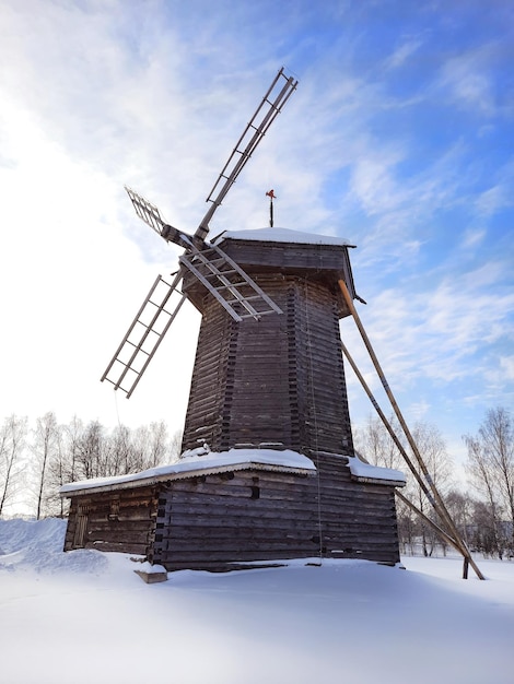 Moulin à vent traditionnel enneigé d'hiver en bois ancien dans le village