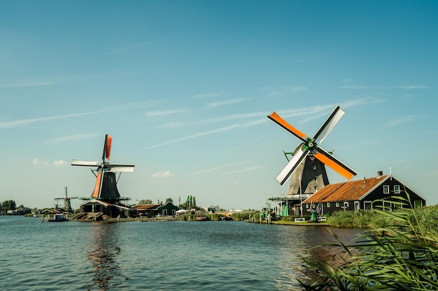 Moulin à vent traditionnel par la rivière contre le ciel