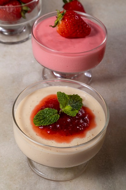 Mousse au citron dans un bol en cristal avec garniture de gelée de fraise et menthe.