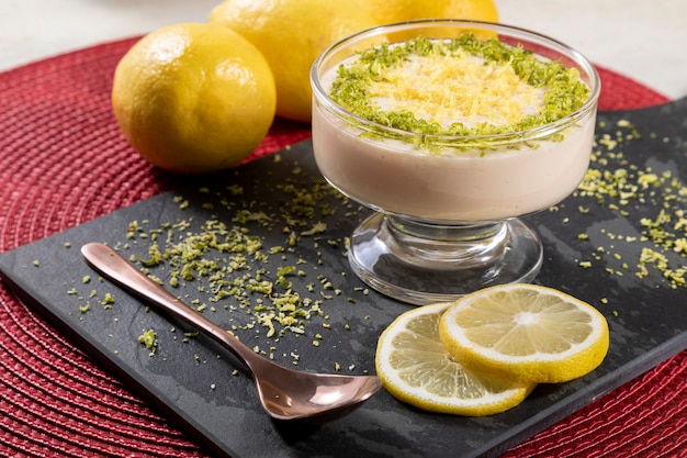 Mousse au citron dans un bol en cristal avec des zestes de citron.