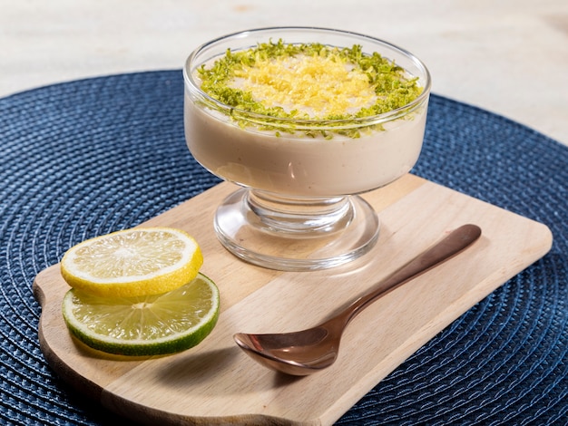 Mousse au citron dans un bol en cristal avec des zestes de citron.