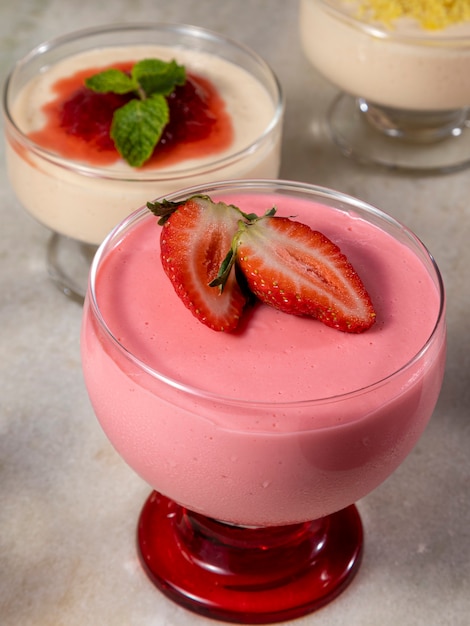 Mousse aux fraises savoureuse en verre avec fraise sur le dessus.