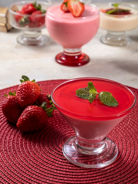 Mousse aux fraises savoureuse en verre avec de la gélatine sur le dessus.