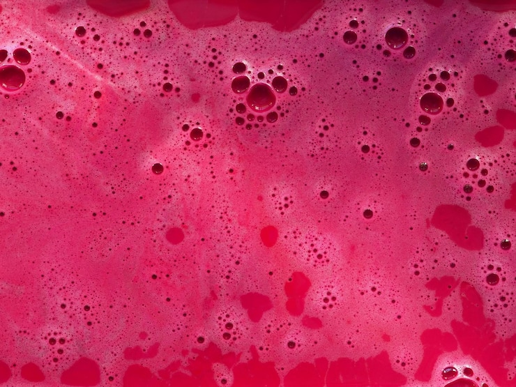 Photo mousse de bain colorée magenta avec des bulles dans l'eau