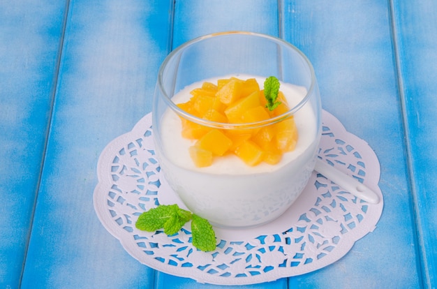 Mousse bavaroise à la vanille et pêches au sirop dans un verre