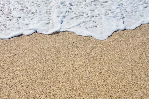 Mousse blanche sur une plage de sable