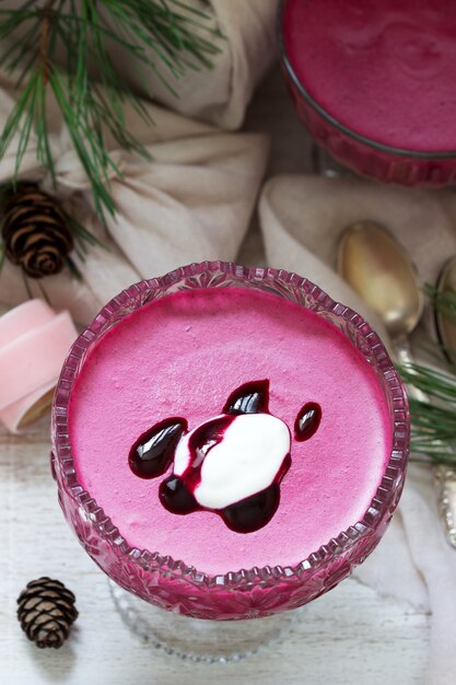 Mousse de cassis, orange et crème dans un bol en verre. Style rustique.