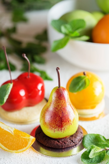 Mousse dessert en forme de poire, fruit orange et cerise
