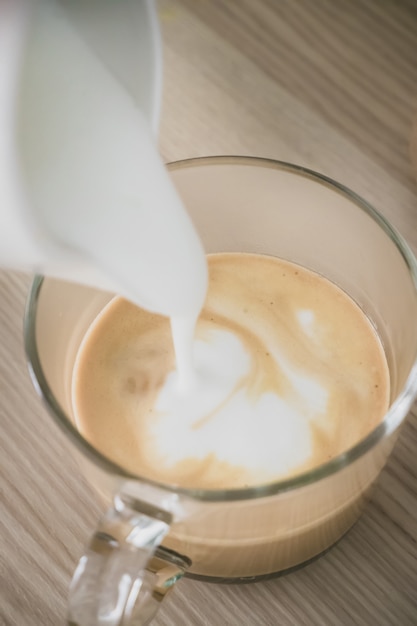 Photo de la mousse de lait se déverse dans le café.