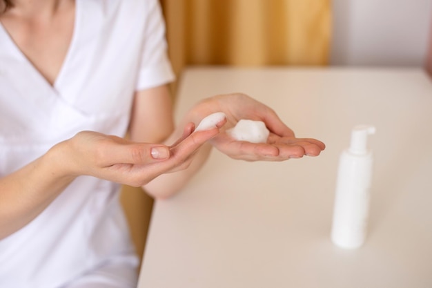 Mousse pour le lavage appliquée sur les mains des femmes