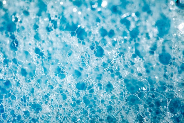 Mousse sur la surface du détergent liquide bleu produits chimiques ménagers grandes et petites bulles gros plan pleine profondeur de vue de dessus de champ