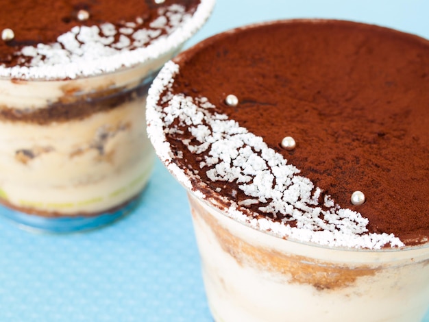 Mousse tiramisu avec décoration personnalisée servie dans un gobelet en plastique.