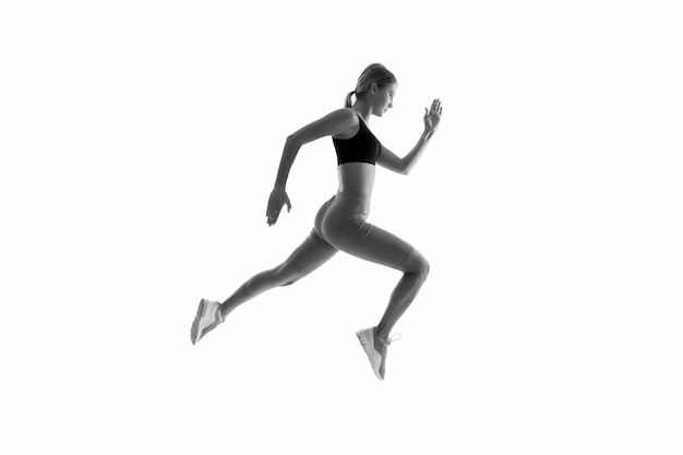 Mouvement dynamique Coureur de femme isolé sur blanc Jogger en cours d'exécution Coureur sportif dans des vêtements de sport à la mode Fitness course motivation sportive Fort et en forme Athlétique sprinter ou coureur Meilleur coureur