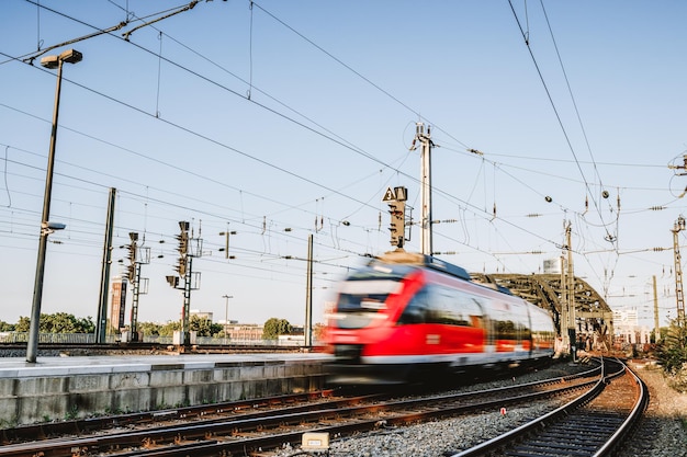 Mouvement flou du train se déplaçant sur les voies ferrées contre le ciel
