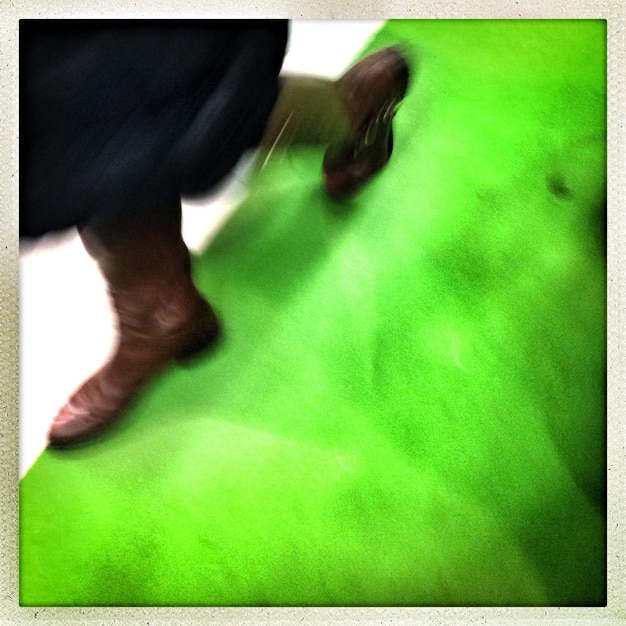 Mouvement flou d'une femme marchant sur le sol vert