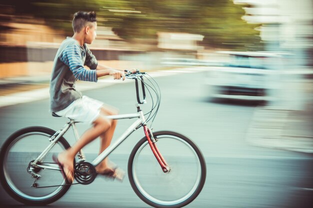 Photo mouvement flou d'un garçon à vélo sur la route