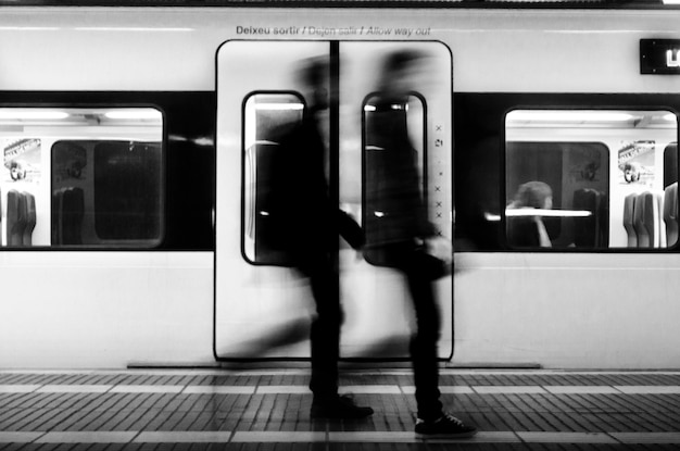 Mouvement flou des gens qui marchent dans le train à la gare