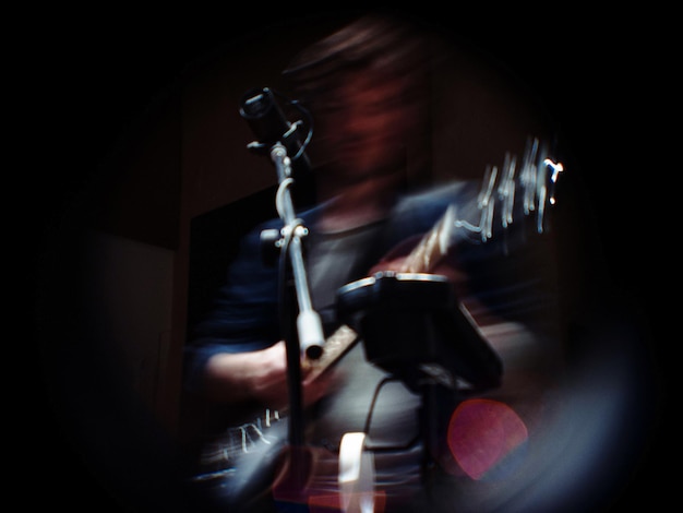 Mouvement flou d'un homme jouant de la guitare pendant un concert