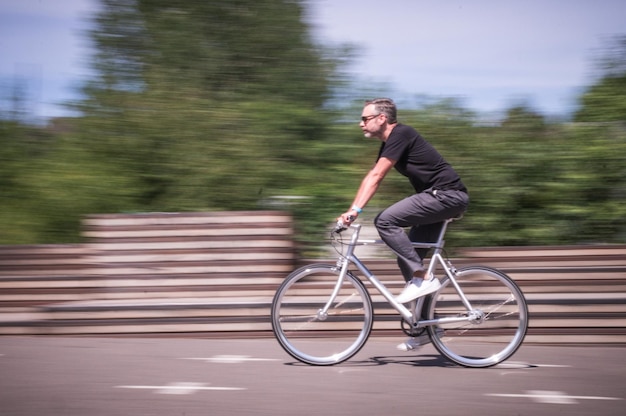 Mouvement flou d'un homme à vélo sur la route